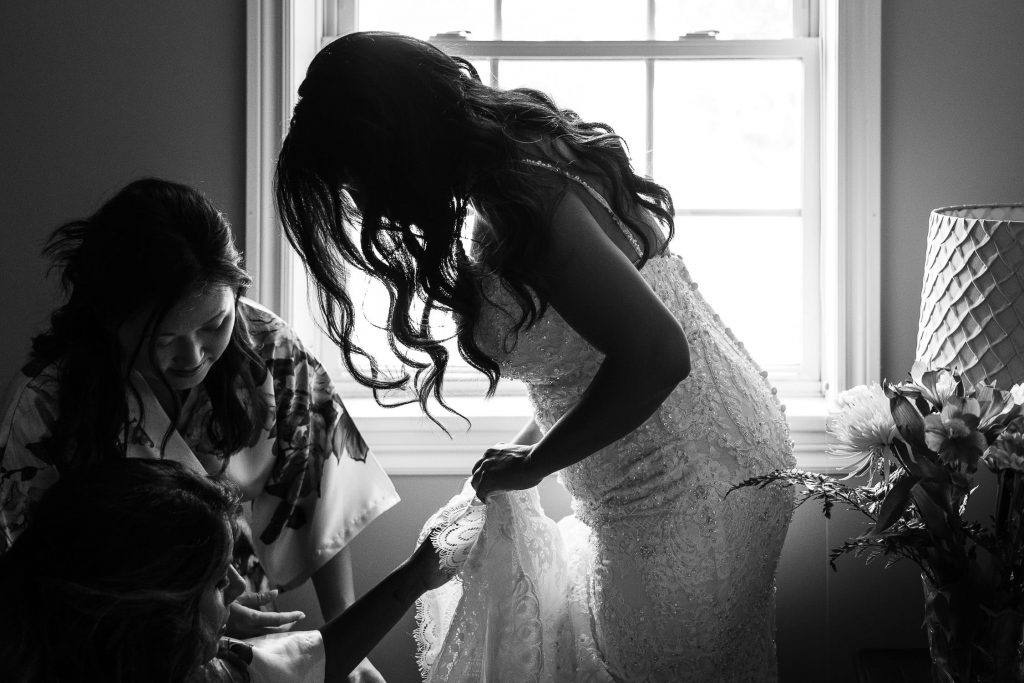 bride putting on wedding dress in PEC home