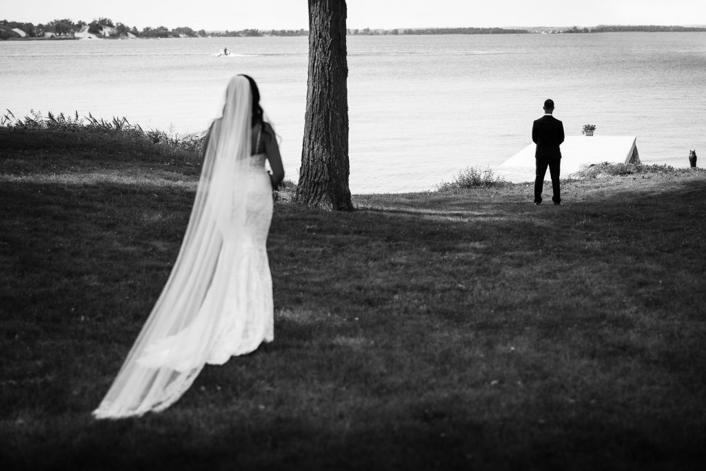 bride walking to groom first look on banks of west lake