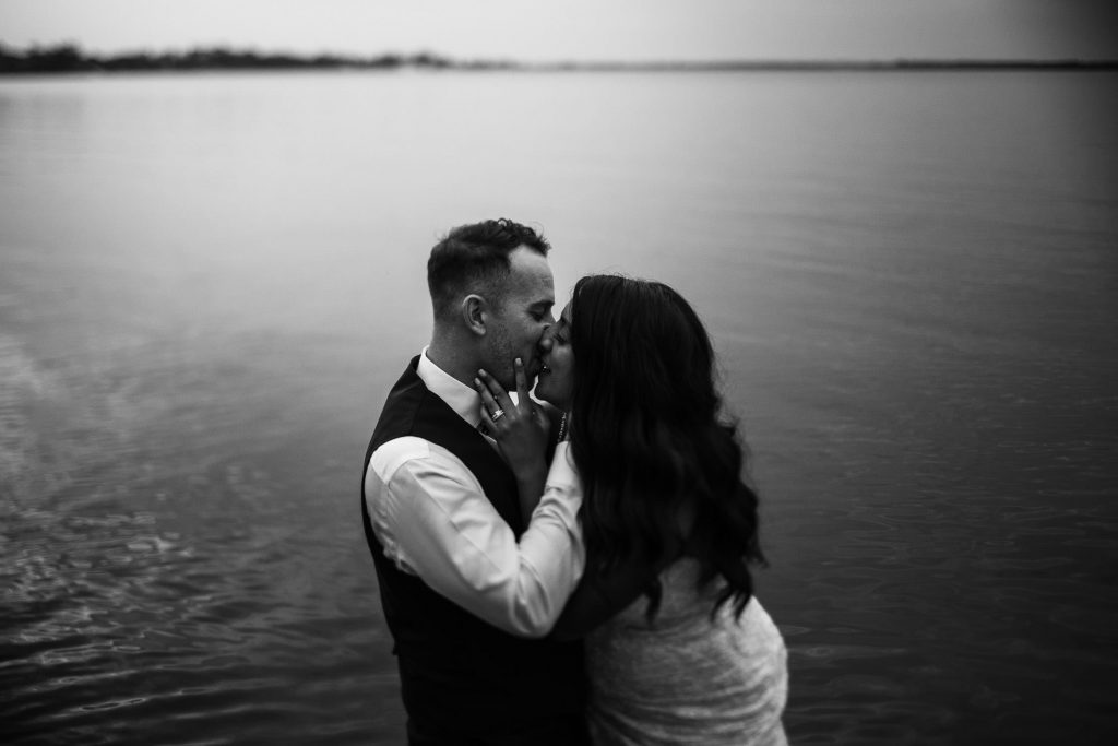 bride and groom kiss in lake in prince edward county