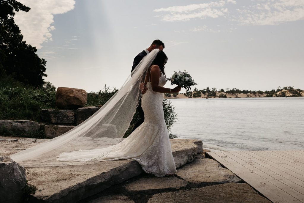 bride and groom walk onto prince edward county dock