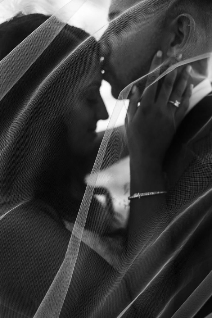 bride and groom under veil at pec backyard wedding