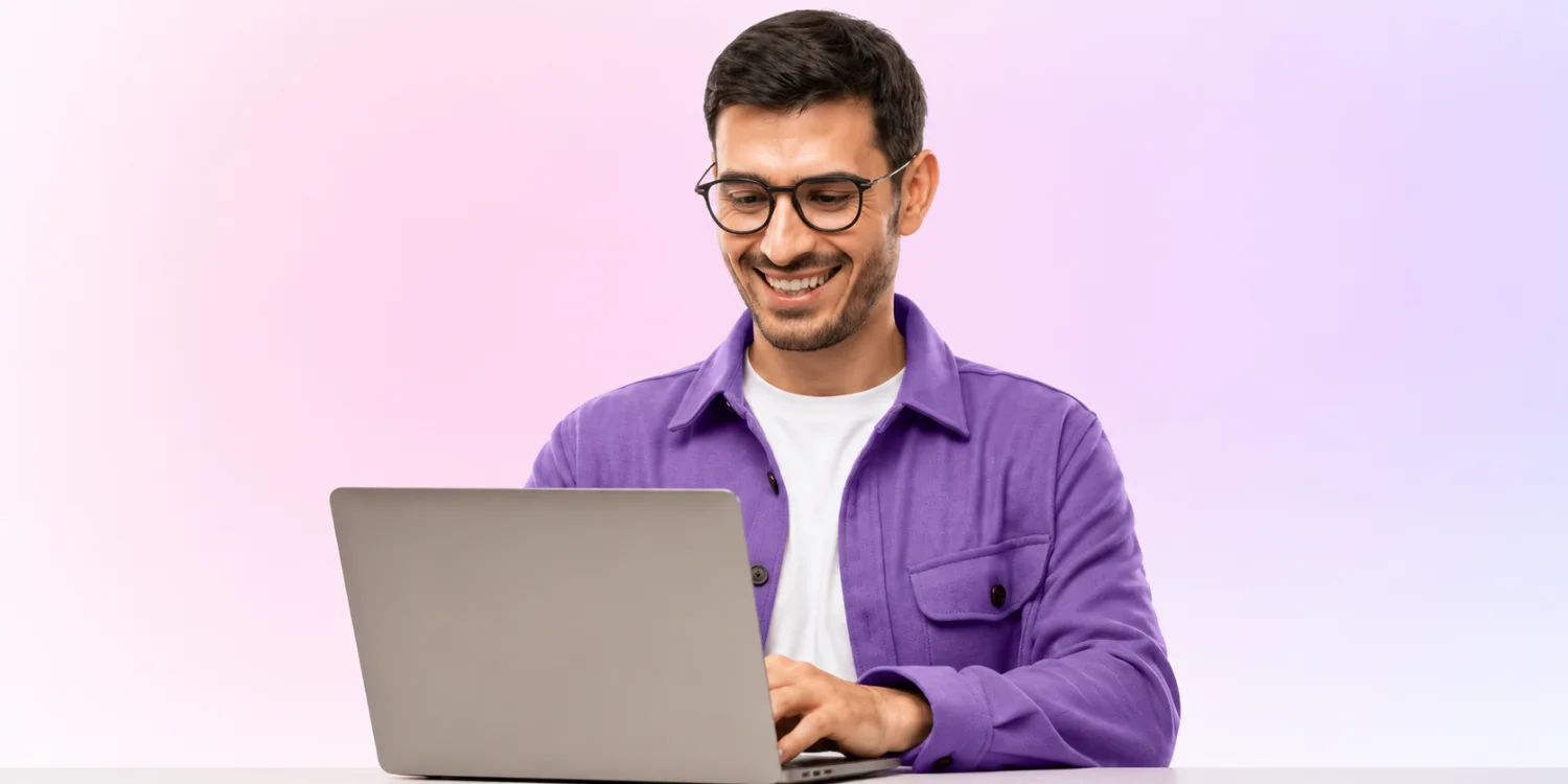 Professional man working on a laptop against a soft pastel gradient background for an Awin vs Partnerize affiliate marketing comparison article.