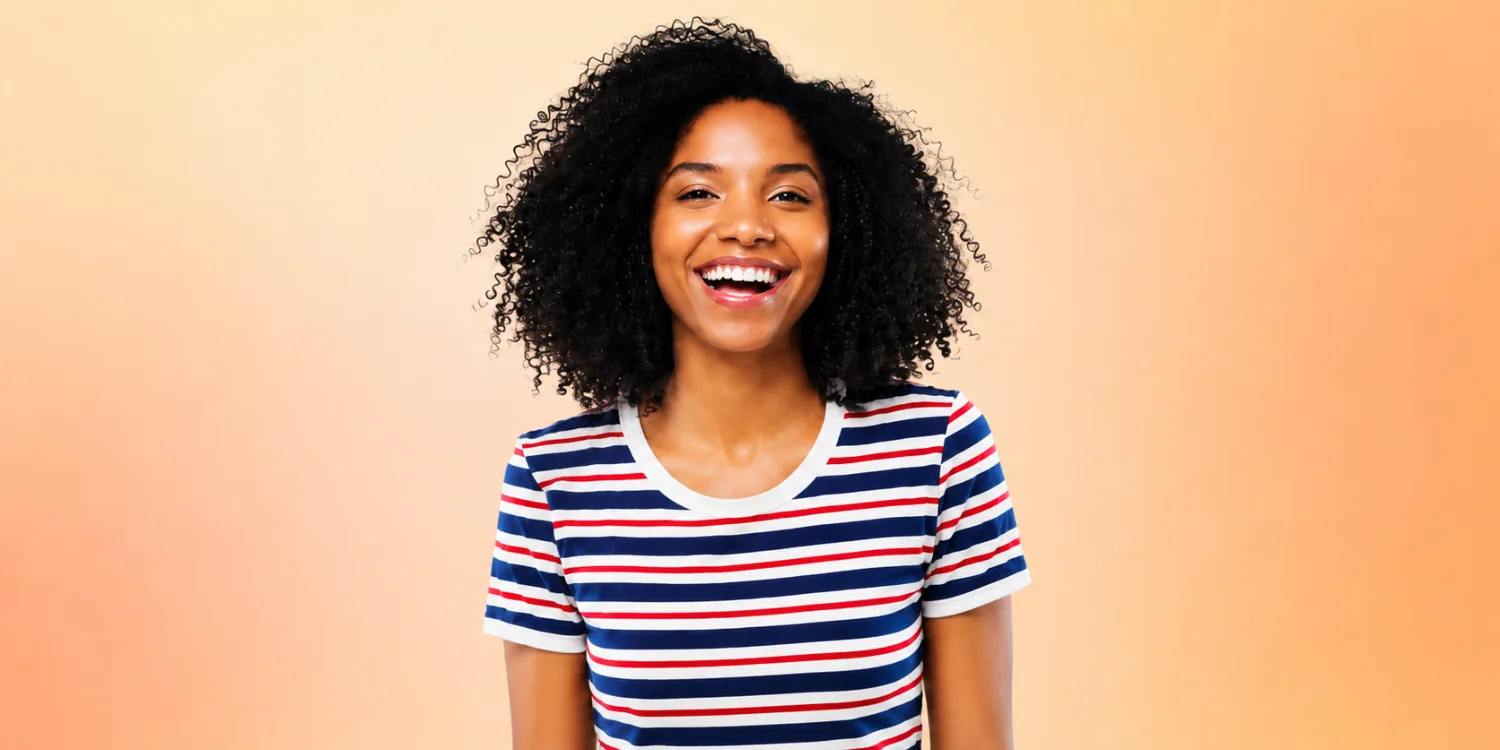Smiling woman on a soft orange gradient background for an Awin vs Rakuten Advertising affiliate marketing comparison article.