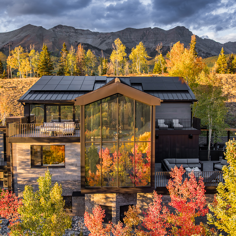 A modern glass wall looking out a mountainous landscape. 
