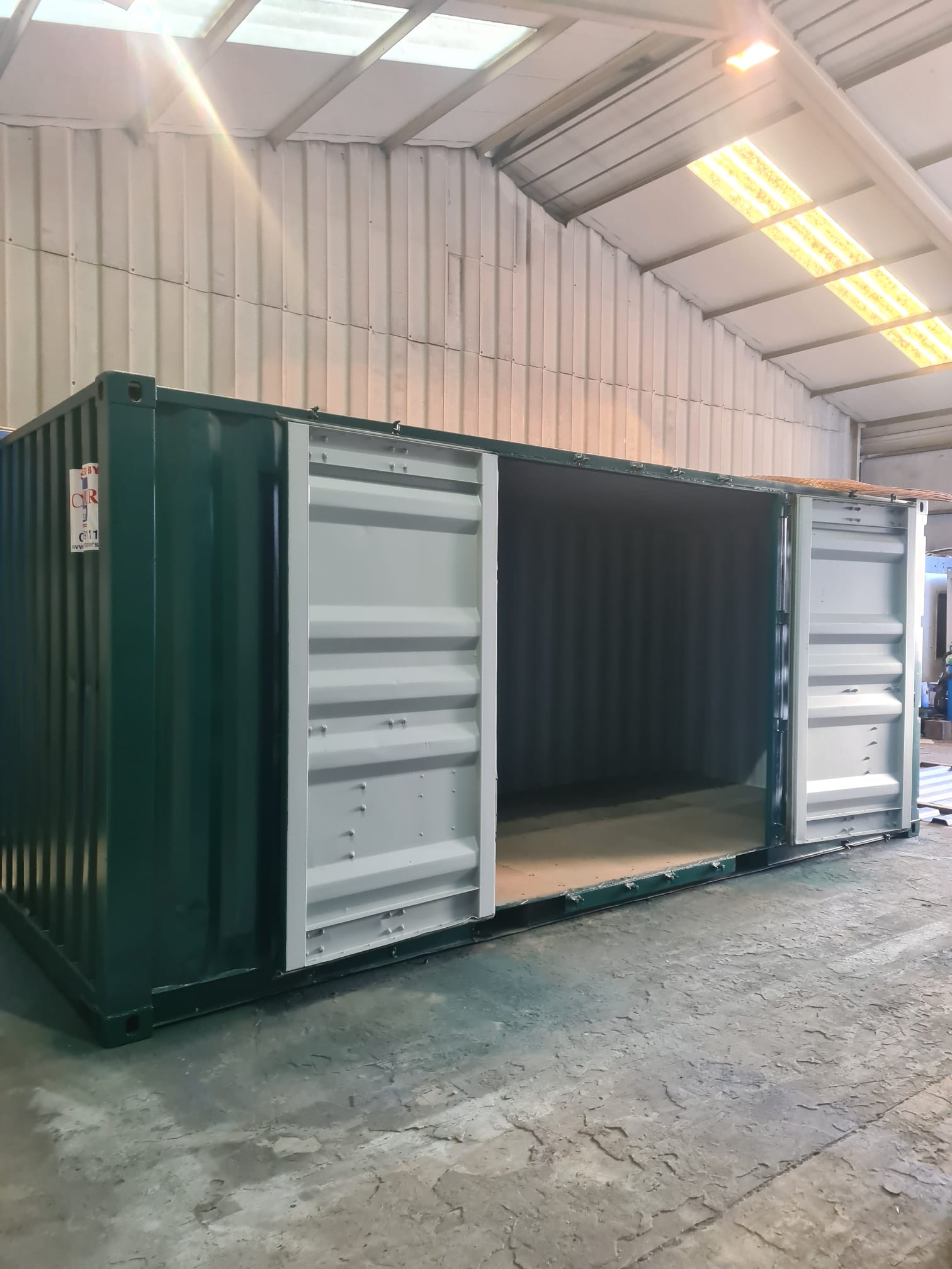 A Used 20ft shipping container with additional side access door for secure storage finished in bottle green RAL 6007.