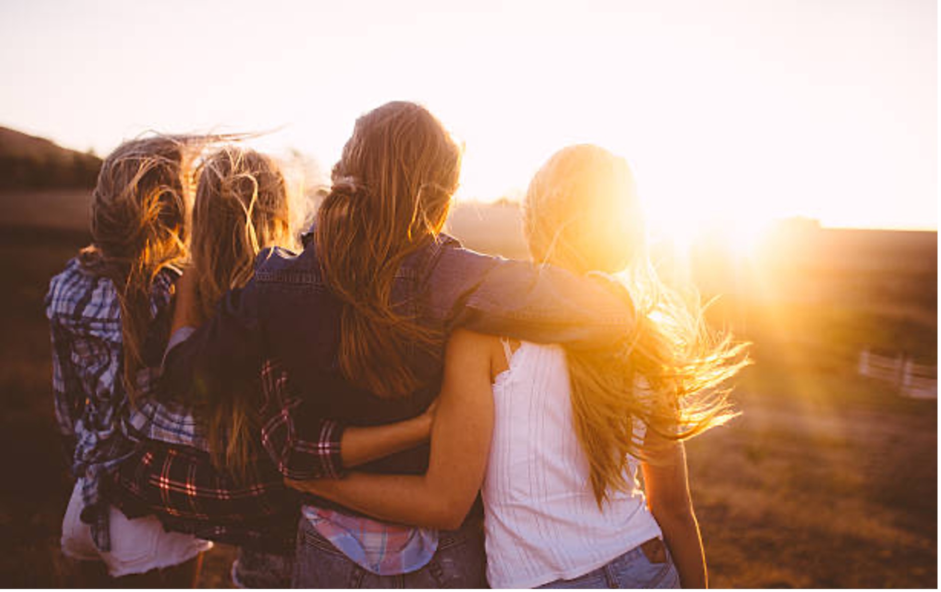 Des amies de dos, au coucher du soleil