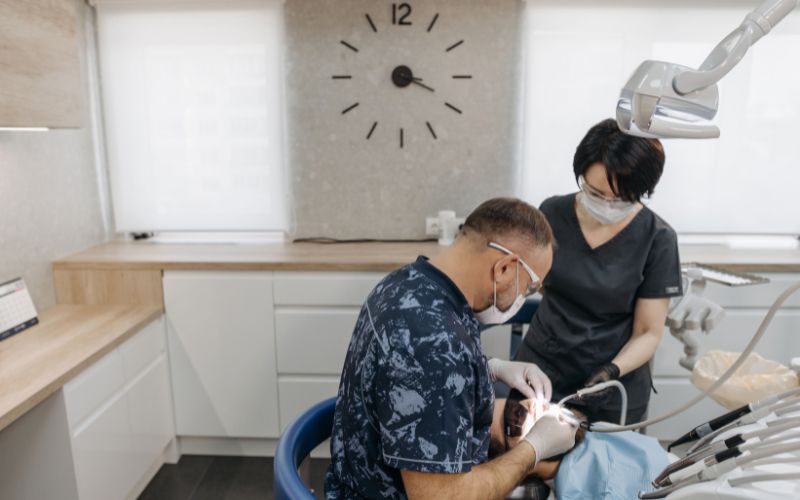 Stomatolog z asystentką podczas zabiegu w gabinecie dentystycznym