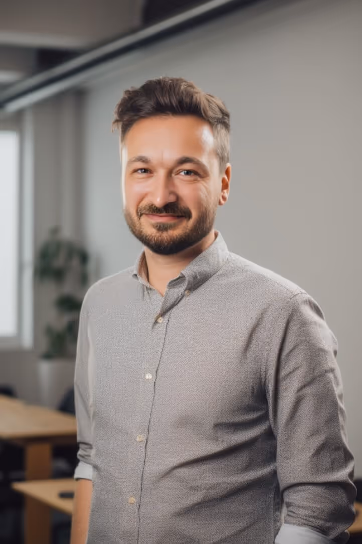 Sebastian von uberneu stands in a bright office at the uberneu agency in Berlin and smiles at the camera