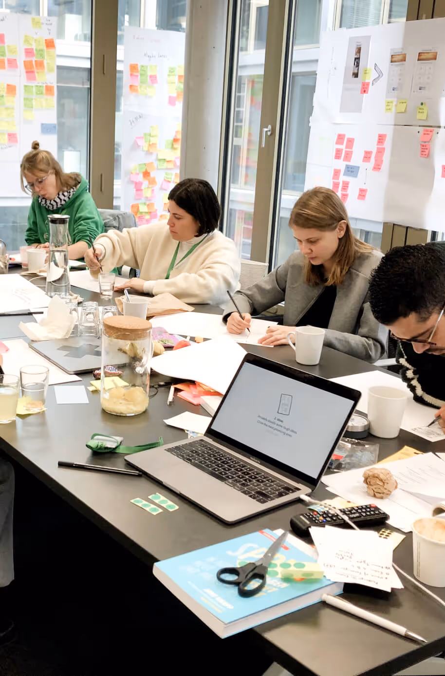 The team sits at the table and outlines ideas during a workshop