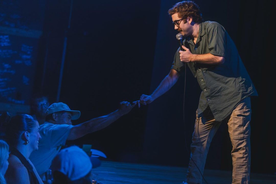 A man standing on a stage holding a microphone.