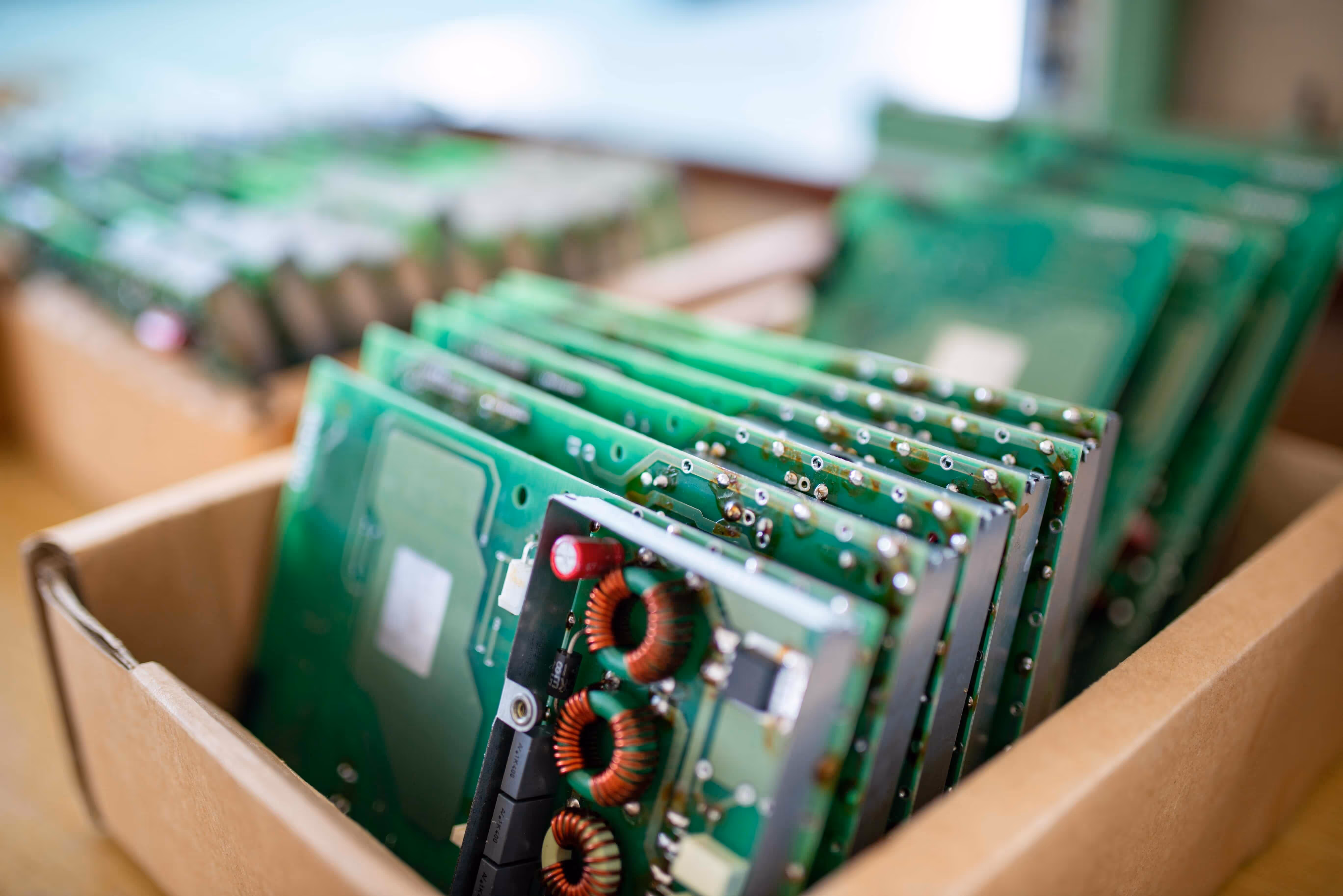 Schede di controllo verdi di monitor TFT impilate in una scatola.