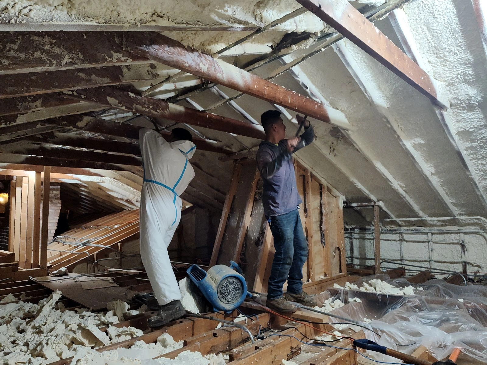 Two Workers Removing Spray Foam