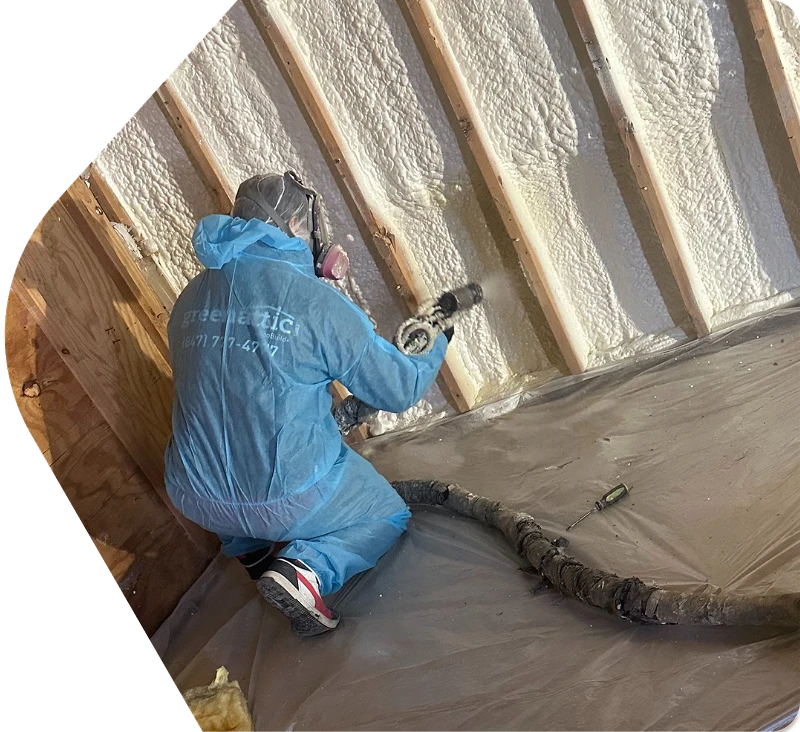 Professional installer applying spray foam insulation to basement wall studs