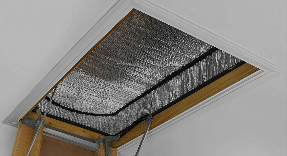 Reflective attic door insulation cover sealing an attic stair opening from inside the home.