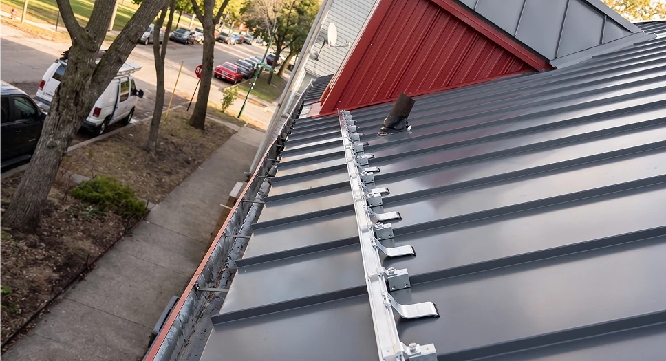 Standing seam metal roof with snow guards installed for added winter protection.
