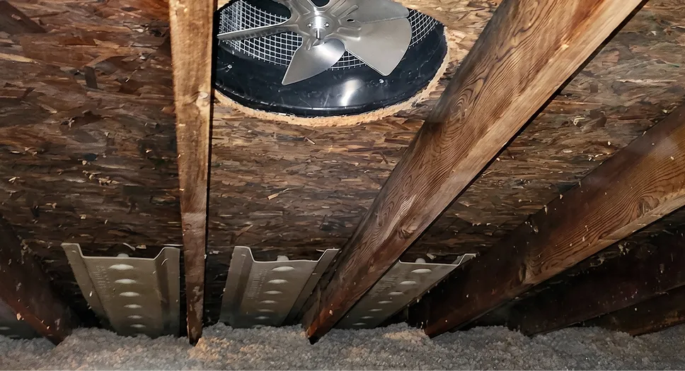 Attic roof ventilation fan viewed from inside the attic to support fresh air exchange.