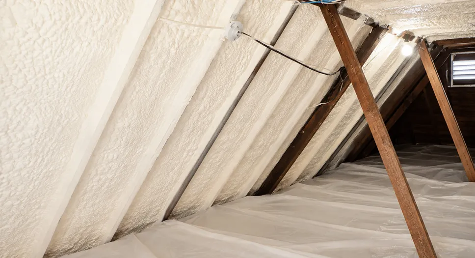 Spray foam insulation applied in an attic for better summer energy efficiency