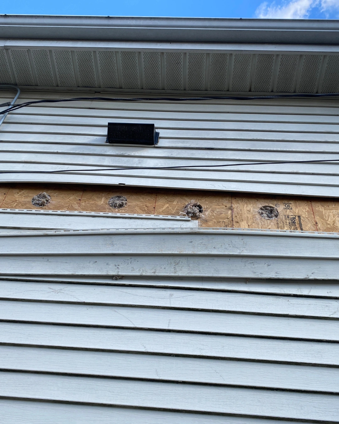 Types of Soffit Materials for Attic Ventilation Different soffit material types shown on a home's eaves, including wood, vinyl, and aluminum