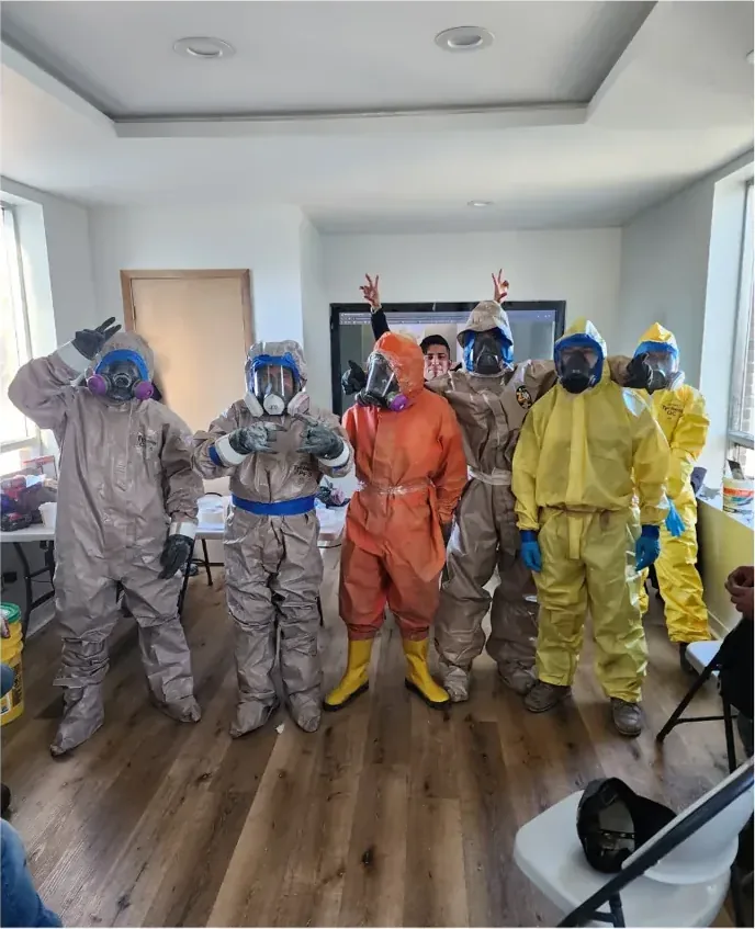 Green Attic Insulation crew in protective hazmat suits and respirators during mold treatment training