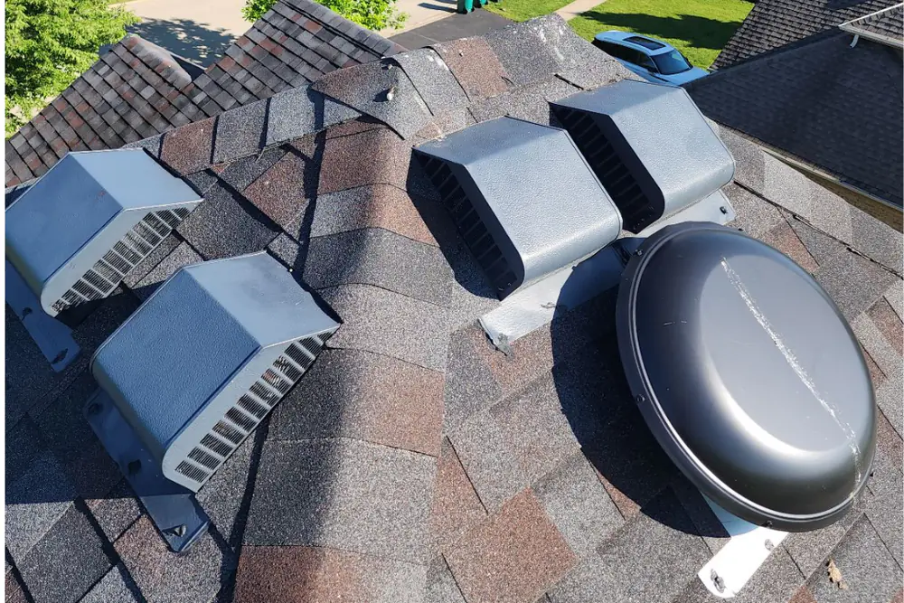 Four static box vents and a powered roof vent installed on the same shingle roof slope