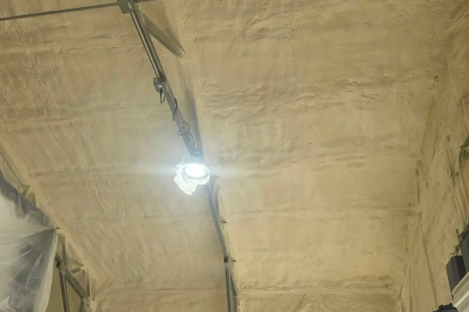 Spray foam insulation applied to a pole barn ceiling and wall panels