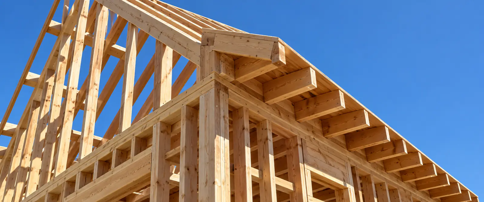Roof framing showing rafter tails at the eave and the gable end overhang forming the rake