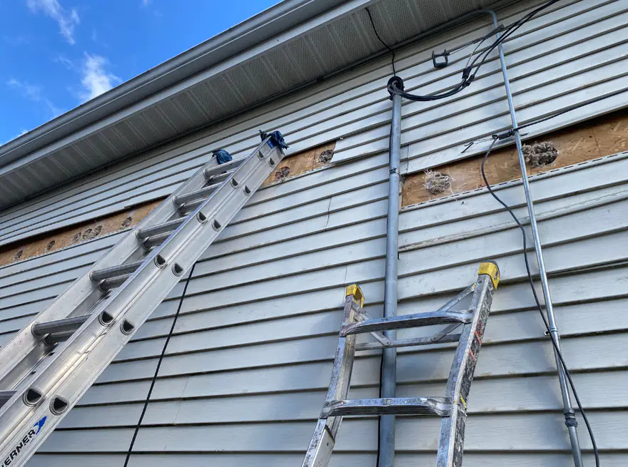 Vented soffit above a wall with siding removed for insulation work
