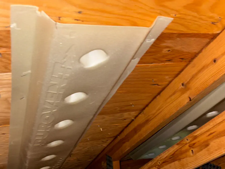 Insulation baffle installed at an attic eave keeping the soffit vent airflow path open
