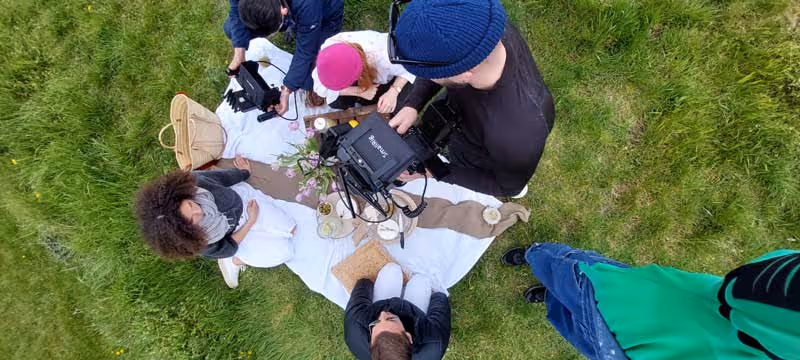 people filming in outdoor location, wild grass