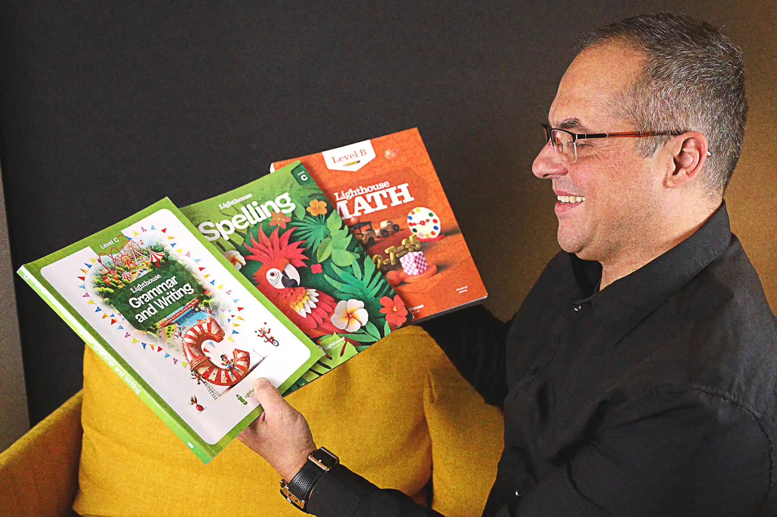 Branko Pejovic holding Math, Spelling, and Grammar & Writing textbooks
