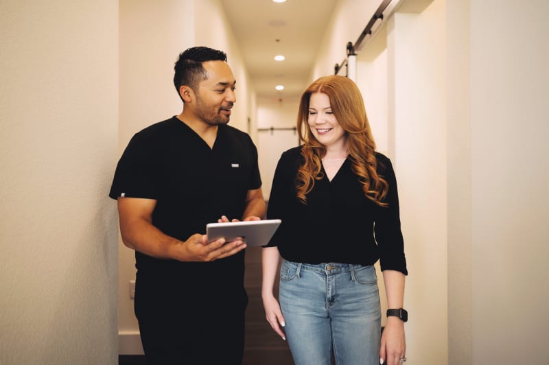 Dentist and patient walking down hallway at dental studio