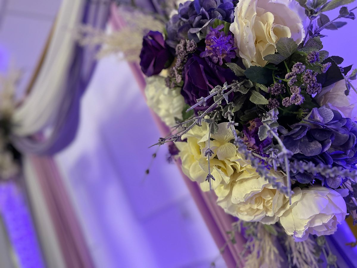 Close-up of a captivating purple and cream floral arrangement, with curtains in the backgroundcurtains in the background