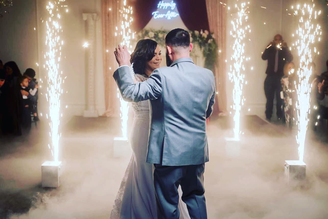 Intimate dance moment between the bride and groom at The Palmyra Venue in New Jersey, with atmospheric smoke and enchanting lights