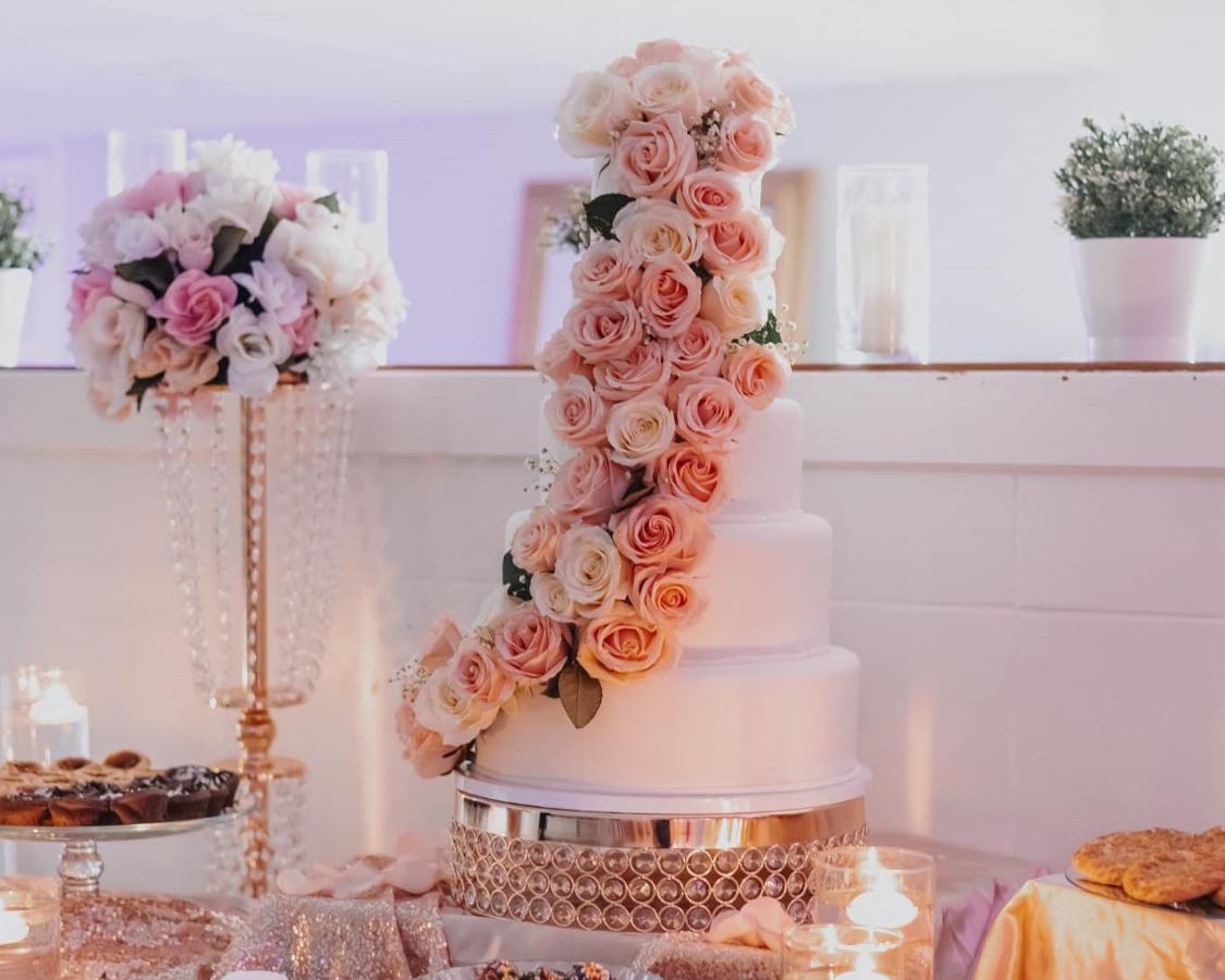 Elegant layered cake adorned with delicate pink flowers, showcased on a stunning gold, white, and pink decoration, celebrating a memorable 60th birthday milestone at The Palmyra Venue in New Jersey.