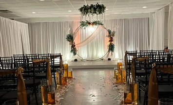 Modern and beautiful fall-toned ceremony space adorned with white petals on the ground at The Palmyra Venue in New Jersey.