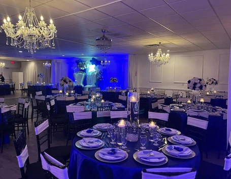 Elegant blue-themed tables adorned with candles in the center, creating a romantic ambiance at The Palmyra Venue.
