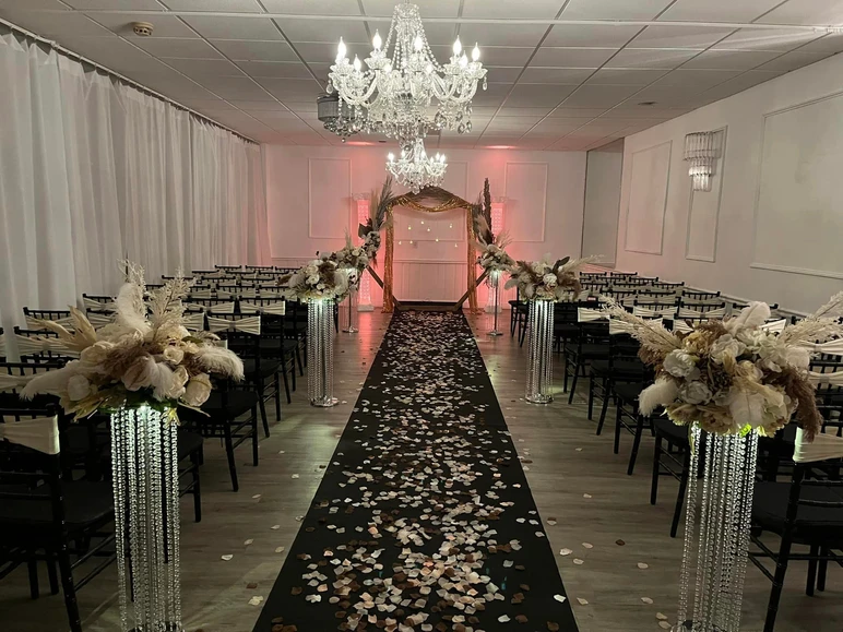 Captivating ceremony space at The Palmyra Venue in New Jersey, adorned in brown, gold, and beige tones with scattered petals for a memorable wedding vows moment