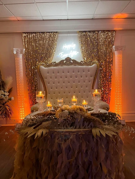 Beautifully adorned chair for the bride and groom in brown and beige hues, complemented by gold curtains at The Palmyra Venue in New Jersey