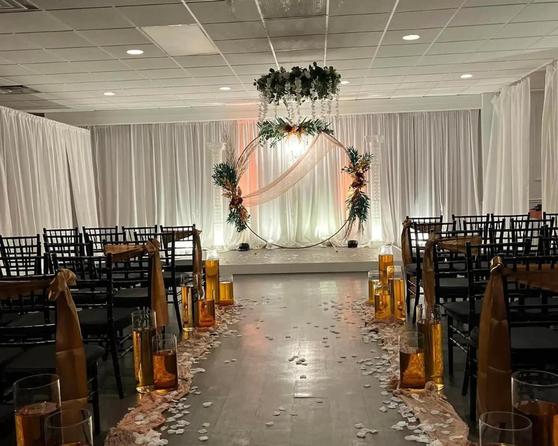Modern and beautiful fall-toned ceremony space adorned with white petals on the ground at The Palmyra Venue in New Jersey.