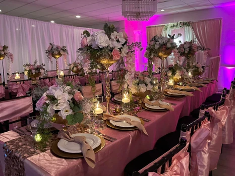 The Palmyra Venue in New Jersey exquisitely decorated with rectangular tables, adorned with a captivating pink and gold theme. 