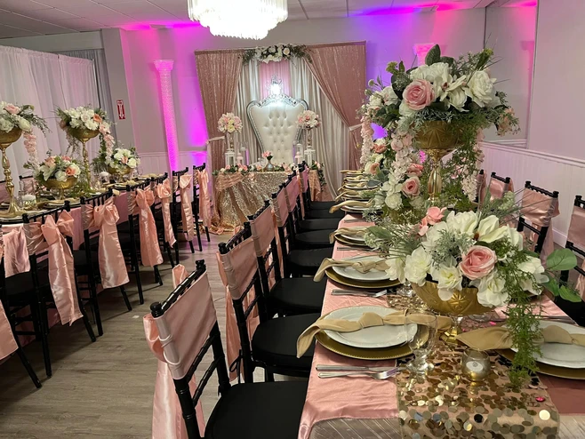 The Palmyra Venue in New Jersey exquisitely decorated with rectangular tables, adorned with a captivating pink and gold theme. 