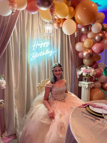 Joyful bride and groom seated on chairs, surrounded by stunning floral decorations in warm fall colors at The Palmyra Venue in New Jersey