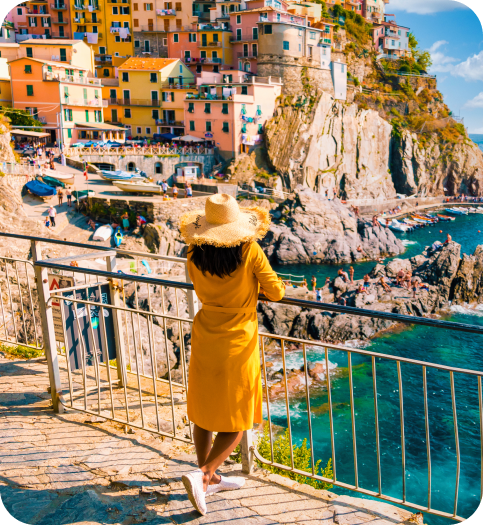 Traveller in a yellow coat looking over a colourful coastal village