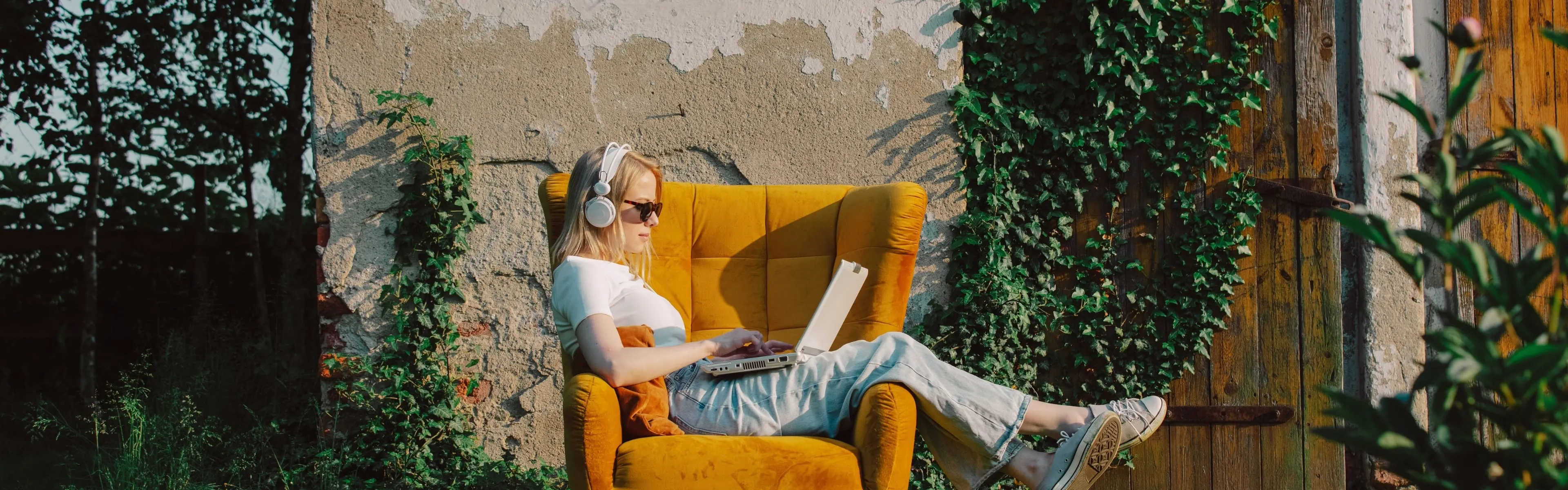 Woman sitting in a yellow chair with a laptop