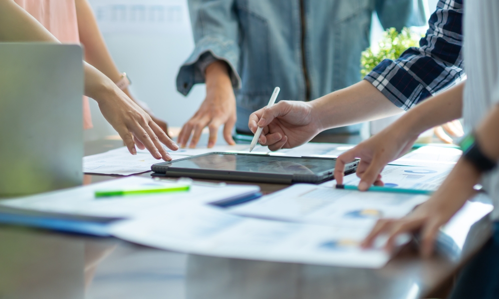 Tablets on table and people discussing information