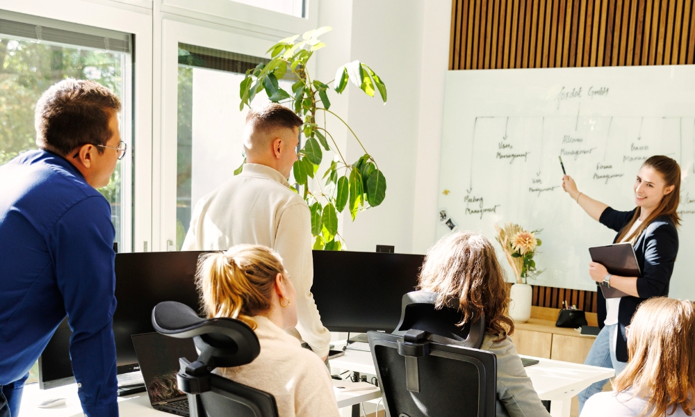Mitarbeiter sitzen vor dem Whiteboard im Büro