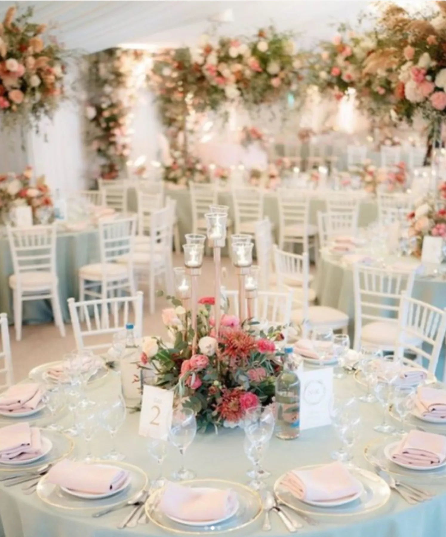 Exquisite and contemporary wedding reception in a light-filled pavilion, adorned with an abundance of beautiful florals and luxurious cutlery and glassware.