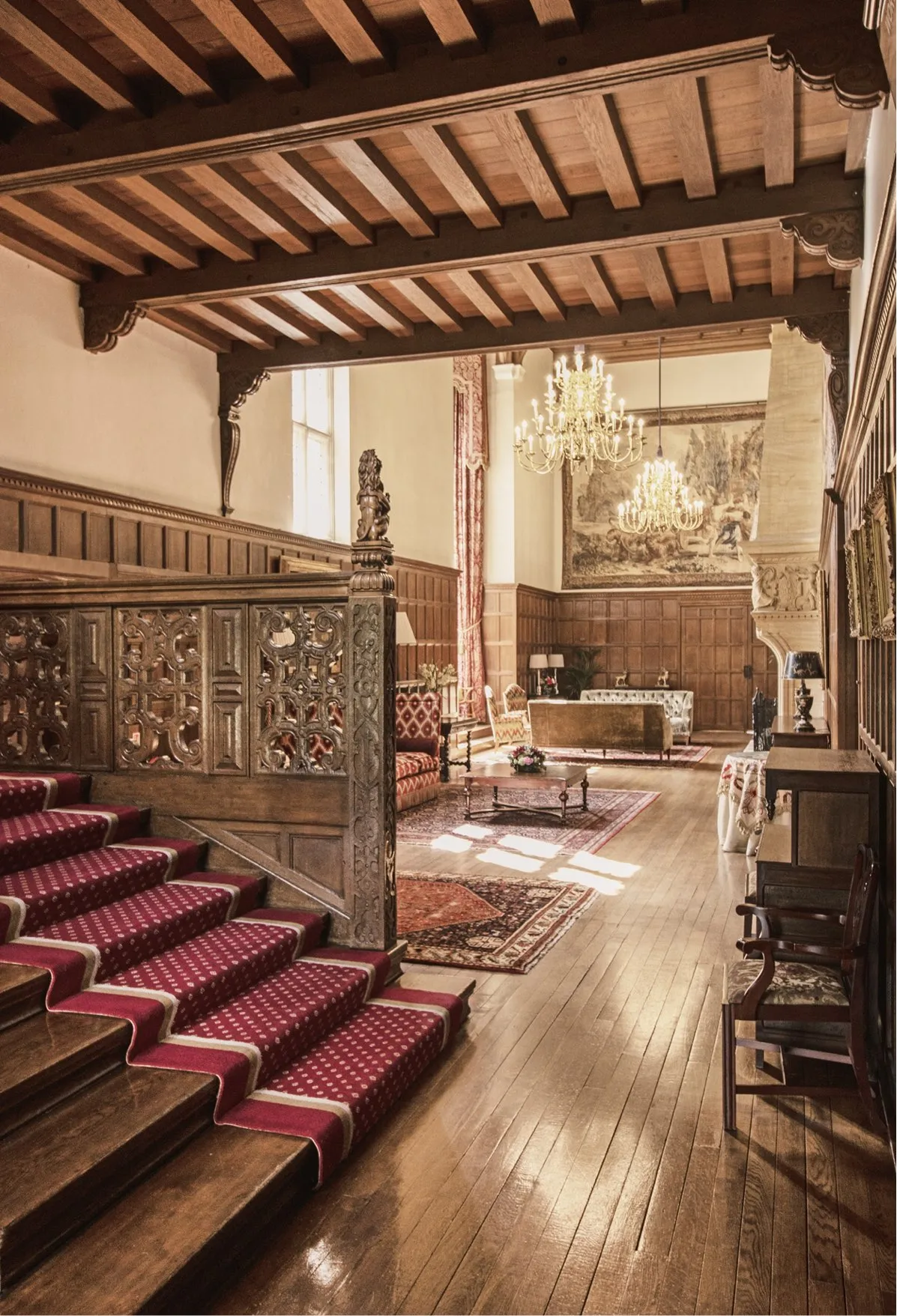 Interior room in the mansion house showcasing Elizabethan architecture with a wooden staircase and wooden paneling