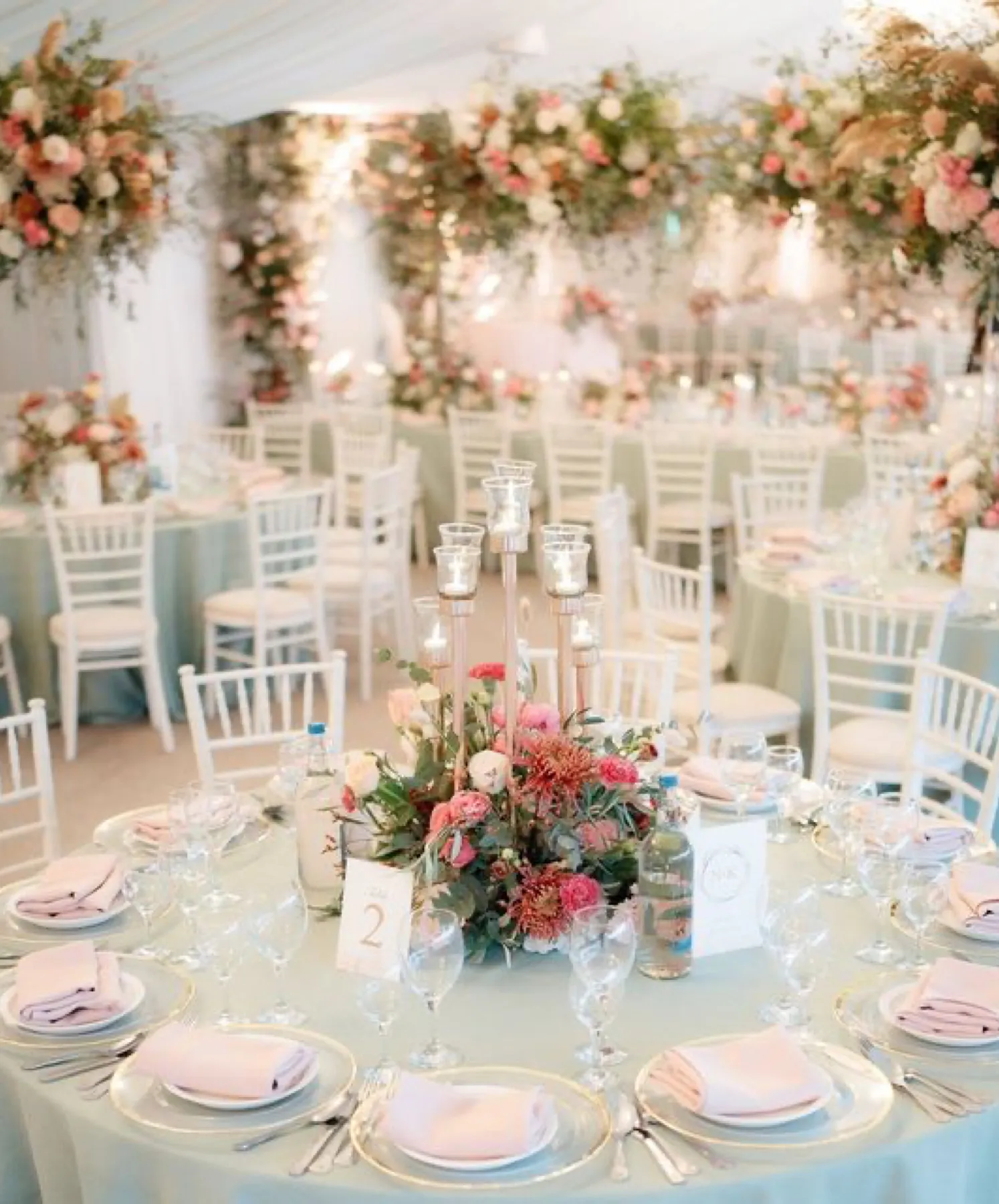 Exquisite and contemporary wedding reception in a light-filled pavilion, adorned with an abundance of beautiful florals and luxurious cutlery and glassware.
