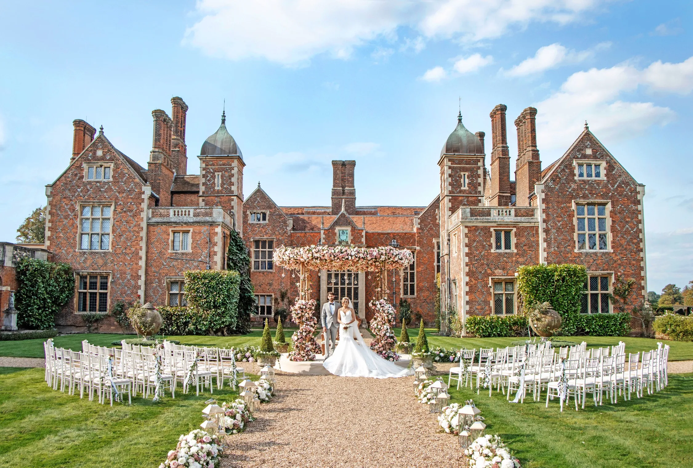 Stunning chuppah religious setup in the South Lawn of North Mymms Park, with the magnificent Mansion House providing a breathtaking backdrop